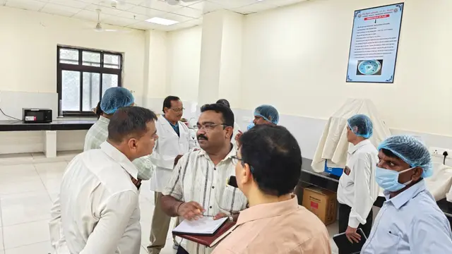Certsure audit team discussing findings with forensic laboratory staff inside a laboratory during an ISO audit